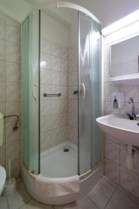 ein Bad mit einer Dusche und einem Waschbecken in der Unterkunft Hotel Forrás Zalakaros in Zalakaros