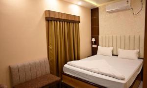 a small bedroom with a bed and a chair at FabHotel Granotel in kolkata
