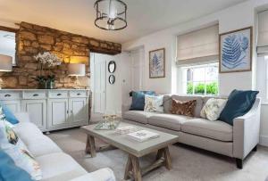 salon z kanapą i stołem w obiekcie A beautiful Cotswolds Cottage in Stroud w mieście Stroud