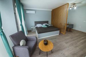 a small room with a bed and a couch and a table at AthmosphereVillaEma Apartments in Kranevo