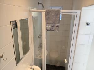 a bathroom with a shower with a toilet and a towel at Urban Manor in Port Elizabeth