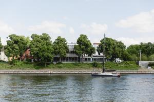 a boat in the water in front of a building at Conventgarten Hotel & Restaurant - direkt am Nord-Ostsee-Kanal in Rendsburg