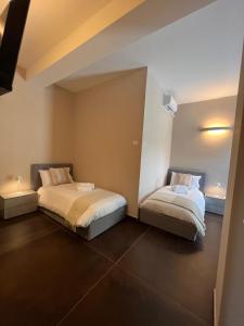 1 dormitorio con 2 camas en una habitación en JOHN'S ROOMS, en Villa D'agri