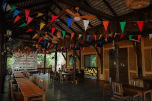 un restaurante con mesas y banderas colgando del techo en Dreamer Club Resort Treehouse Suspension Bridge Pool, en Chiang Mai