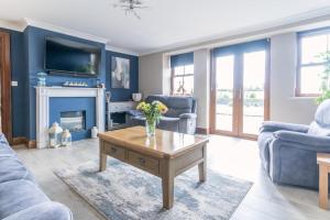 a living room with blue walls and a fireplace at Glenvela in Castlerea