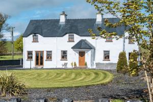 Glenvela guest house في Castlerea: منزل أبيض مع ممر دائري