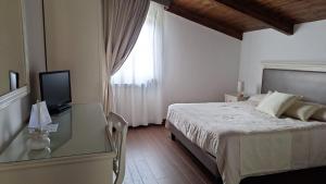 1 dormitorio con 1 cama y escritorio con TV en Il Casale Del Mirto, en Vico Equense