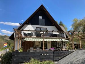 uma casa com um telhado preto e branco em Gasthof Walhalja em Schmallenberg