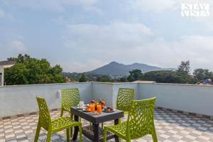 Una mesa y sillas en un patio con vista. en StayVista's Cosmo Zen - Mountain-view villa with Pool, Jacuzzi, and Indoor & Outdoor activities, en Lonavala