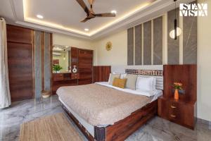 Un dormitorio con una cama y un ventilador de techo. en StayVista's Cosmo Zen - Mountain-view villa with Pool, Jacuzzi, and Indoor & Outdoor activities, en Lonavala 14 fotos más