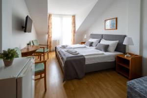 ザラカロシュにあるHotel Forrás Zalakarosのベッドルーム1室(ベッド1台、テーブル、椅子付)