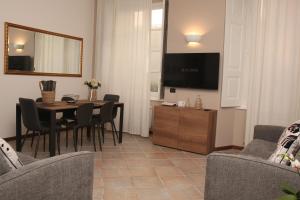 ein Wohnzimmer mit Tisch, Stühlen und Fernseher in der Unterkunft JB in Como in Como