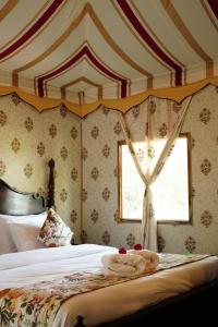 Schlafzimmer mit einem Bett und einem Fenster in der Unterkunft Heli Pushkar in Pushkar