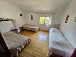 a bedroom with two beds and a window at La Parenthèse avec piscine - les impressionnistes in Frépillon