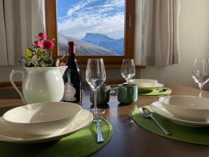 una mesa con platos y copas y una botella de vino en Apartments Stroblhof, en Ortisei