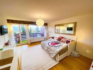 een slaapkamer met een bed en een groot raam bij Studio cosy au calme avec terrasse vue sur Alpes in Crans-Montana