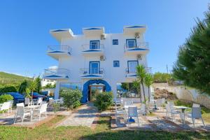 a white building with chairs and tables in front of it at Vila Antica in Ksamil +108 photos