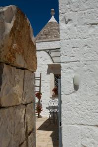 Zugang zu einem weißen Gebäude mit einem Tisch und Stühlen in der Unterkunft Casa Nonna Renzina in Locorotondo