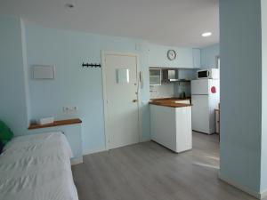 a kitchen with white appliances and a bed in a room at Estudio Roses, estudio, 4 personas - ES-228-112 in Roses