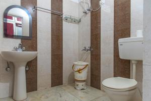 a bathroom with a toilet and a sink at The Mill Family suit , 3beds in Kasauli