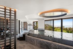 a luxury house with a swimming pool with a large window at Los Jardines de Abama Suites in Guía de Isora