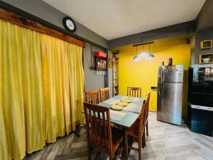 a dining room with a table and a refrigerator at StayCation Homestay in Gangtok