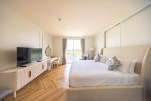 ein Hotelzimmer mit einem Bett und einem Flachbild-TV in der Unterkunft Olivia Boutique Thailand in Ban Bang Kraba