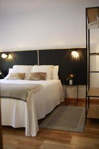1 dormitorio con cama blanca y pared negra en Torrelavega Plaza Center, en Torrelavega