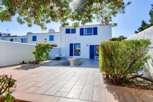 eine Aussicht auf ein weißes Haus mit blauen Fenstern in der Unterkunft Escapade familiale a deux pas de la plage in La Guérinière