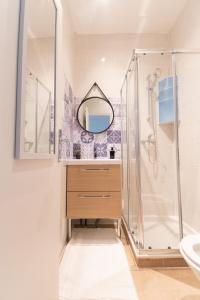 La salle de bains est pourvue d'une douche, d'un lavabo et d'un miroir. dans l'établissement Magnifique duplex à Paris, à Gentilly