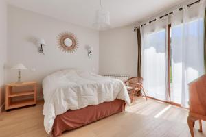 a white bedroom with a bed and a window at Carnac - 7 Voyageurs - 100 % Nature in Crach