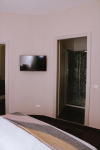 1 dormitorio con cama y espejo en la pared en JOHN'S ROOMS, en Villa D'agri