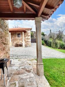 une terrasse en pierre sous une pergola en bois dans l'établissement 3 bedrooms villa with private pool enclosed garden and wifi at Caminha, à Caminha