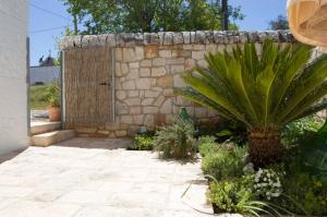 una pared de piedra con una puerta en un jardín en Casa Nonna Renzina, en Locorotondo