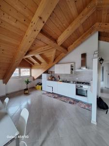 cocina grande con armarios blancos y techo de madera en Casa Matilde, en Leinì