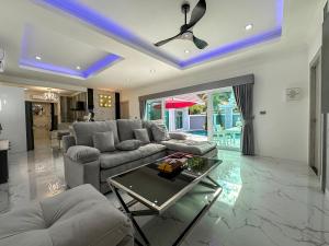 乔木提恩海滩VIEW TALAY VILLAs POOL 67, JOMTIEN BEACH, PATTAYA的客厅里有一张沙发和一张桌子。