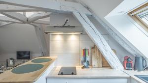 eine Küche im Dachgeschoss mit weißen Schränken und einem Herd in der Unterkunft Preize Serenity Loft - Hypercentre - 2 pers. in Troyes