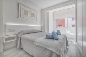 Un dormitorio con una cama con dos almohadas azules encima. en Apartamentos Haranas II & Parking, en Córdoba