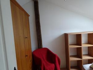 a room with a red blanket sitting on a shelf at chez madame cigogne in Douzy +1 photo