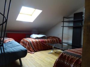 a attic room with two beds and a skylight at chez madame cigogne in Douzy