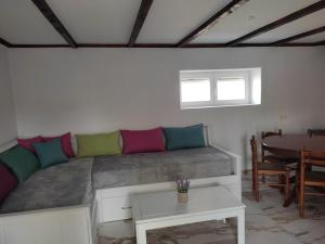 佩夫卡里的住宿－Pefkari Bay House，一张带五颜六色枕头的床,位于带桌子的房间里