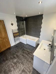 uma casa de banho com uma banheira, um lavatório e um chuveiro em Wolf Hollow, sleeps 6, Buxton centre em Buxton