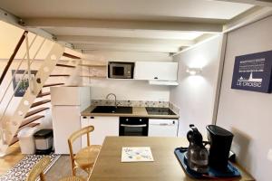 une petite cuisine avec une table et une cuisine avec un escalier dans l'établissement Magnifique appartement plein sud - Piscine, au Croisic