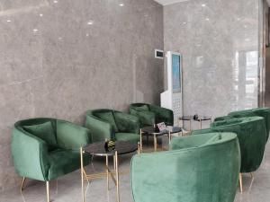 a waiting room with green chairs and tables at Connar Hotel - Shenzhen Shawei in Shenzhen