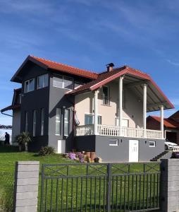 uma casa grande com uma cerca em frente em Apartment Vuleta em Prijedor