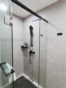 a shower with a glass door in a bathroom at Connar Hotel - Shenzhen Shawei in Shenzhen