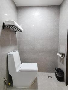 a bathroom with a toilet and a phone on the wall at Connar Hotel - Shenzhen Shawei in Shenzhen