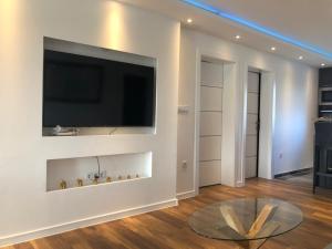 Apartment Vuleta في برييدور: غرفة معيشة مع تلفزيون وطاولة زجاجية