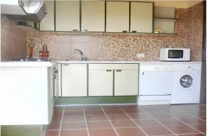 洛哈的住宿－4 bedrooms villa with private pool and furnished terrace at Loja，厨房配有白色橱柜、洗衣机和烘干机