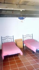 洛哈的住宿－4 bedrooms villa with private pool and furnished terrace at Loja，配有粉红色床单的客房内的两张床